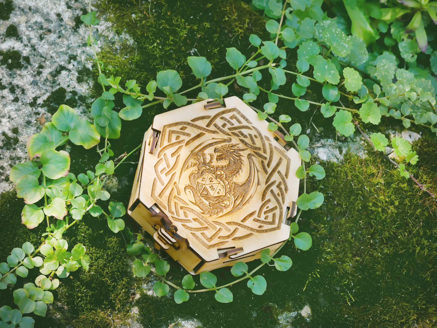 Closed hexagonal wooden dice box with a dragon and Celtic knotwork engraved on the lid
