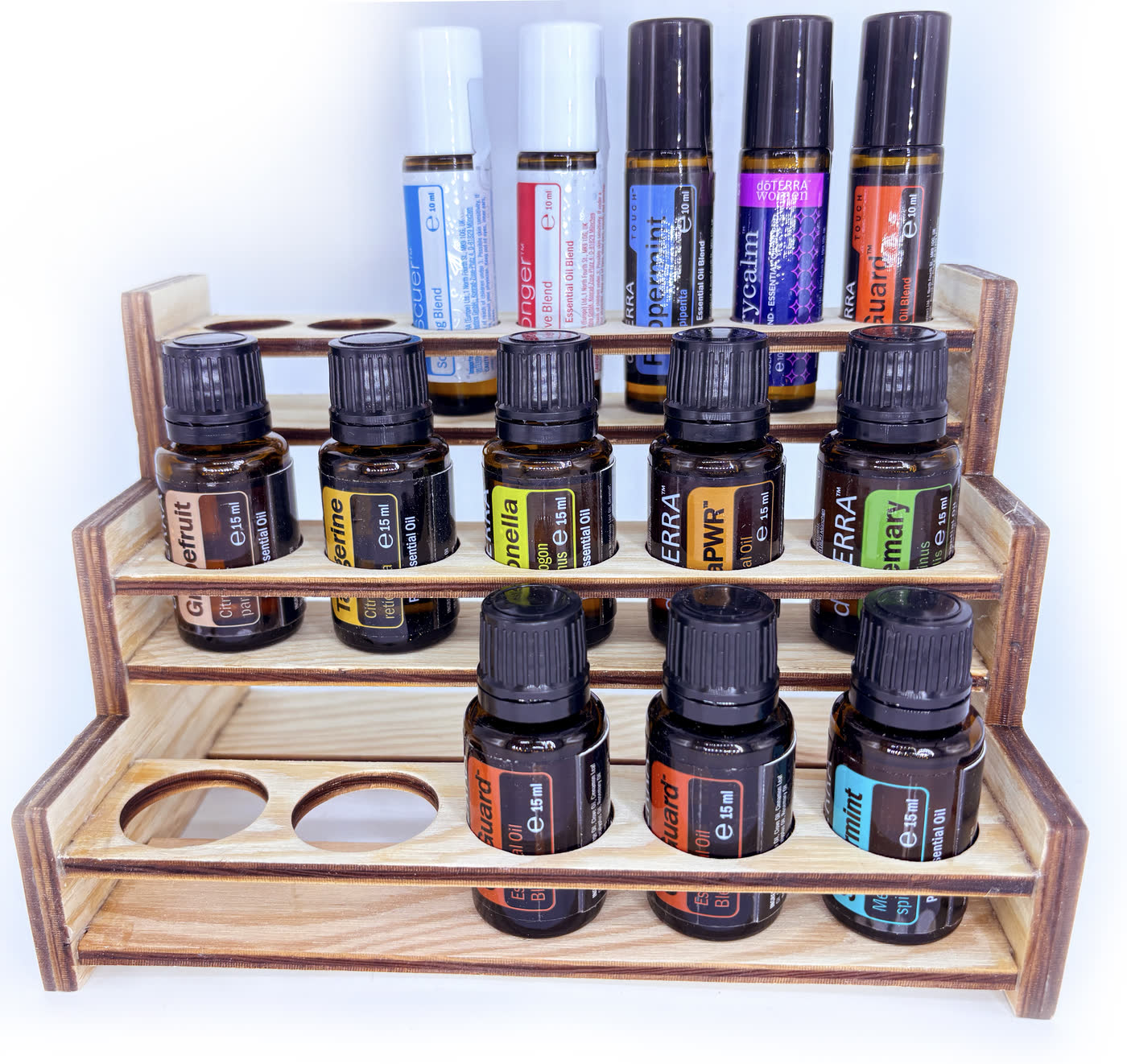 Tiered wooden display rack filled with essential oil bottles, brand wordmark engraved on the front panel